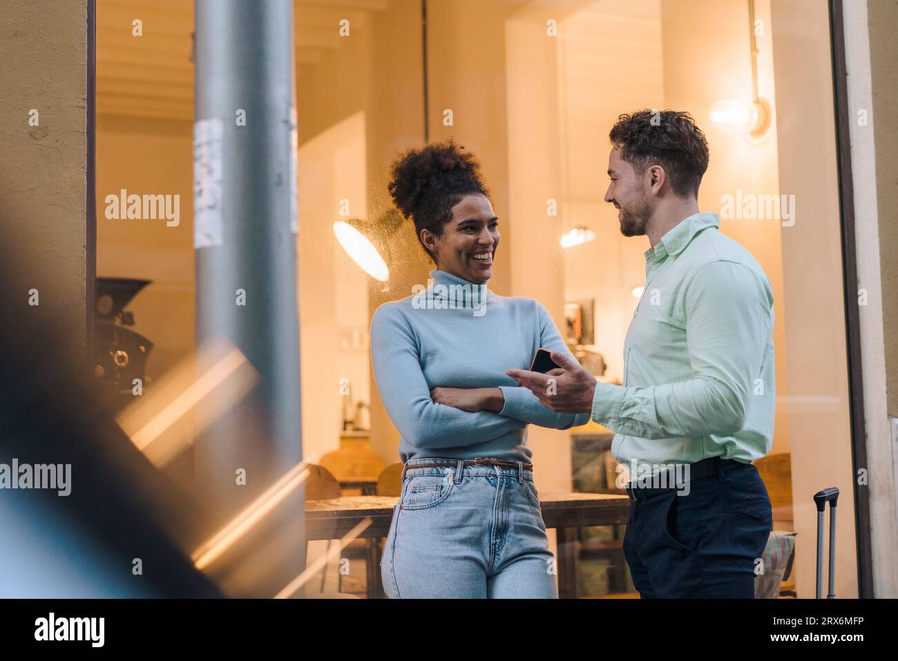 Happy young businessman talking to colleague outside cafe Stock Photo