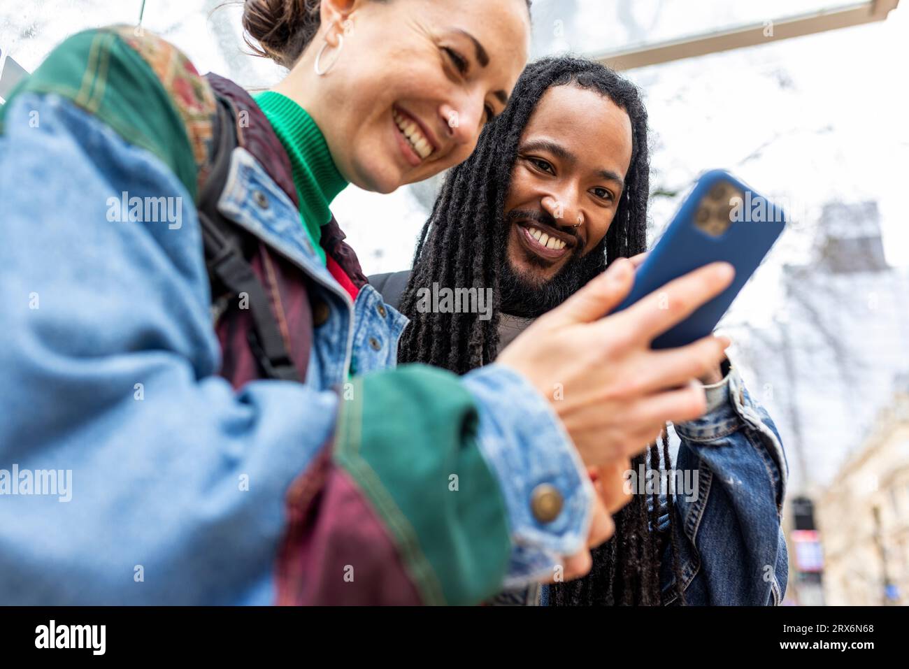 Smiling multiracial couple using smart phone Stock Photo