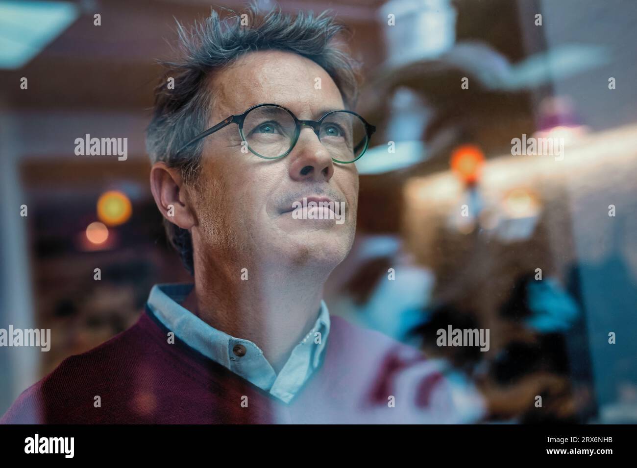 Businessman wearing eyeglasses seen through glass in office Stock Photo