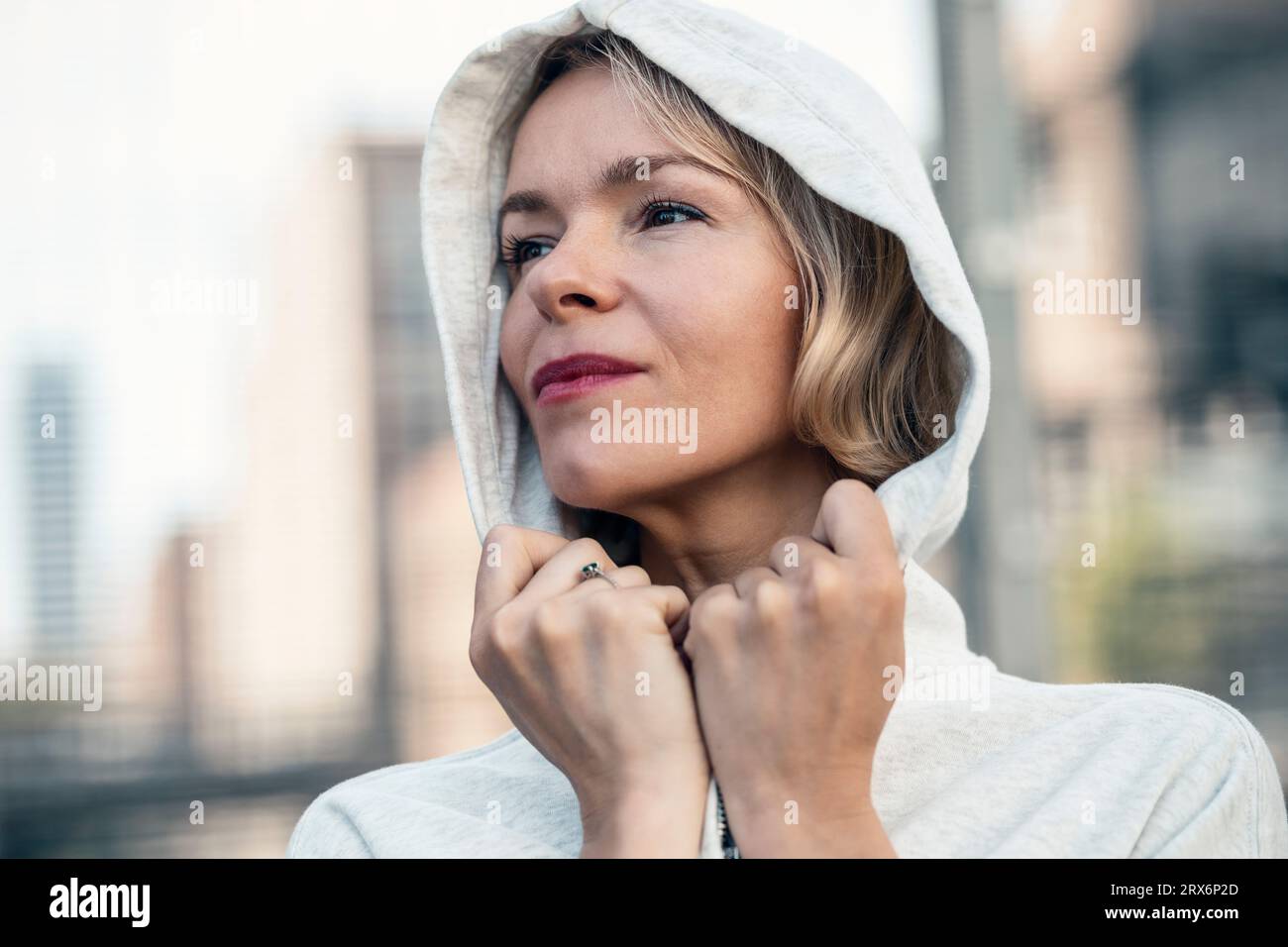Contemplative woman wearing hooded shirt Stock Photo