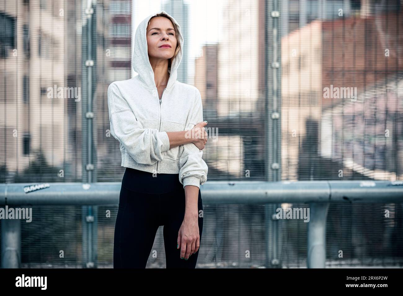 Thoughtful woman standing in front of railing Stock Photo