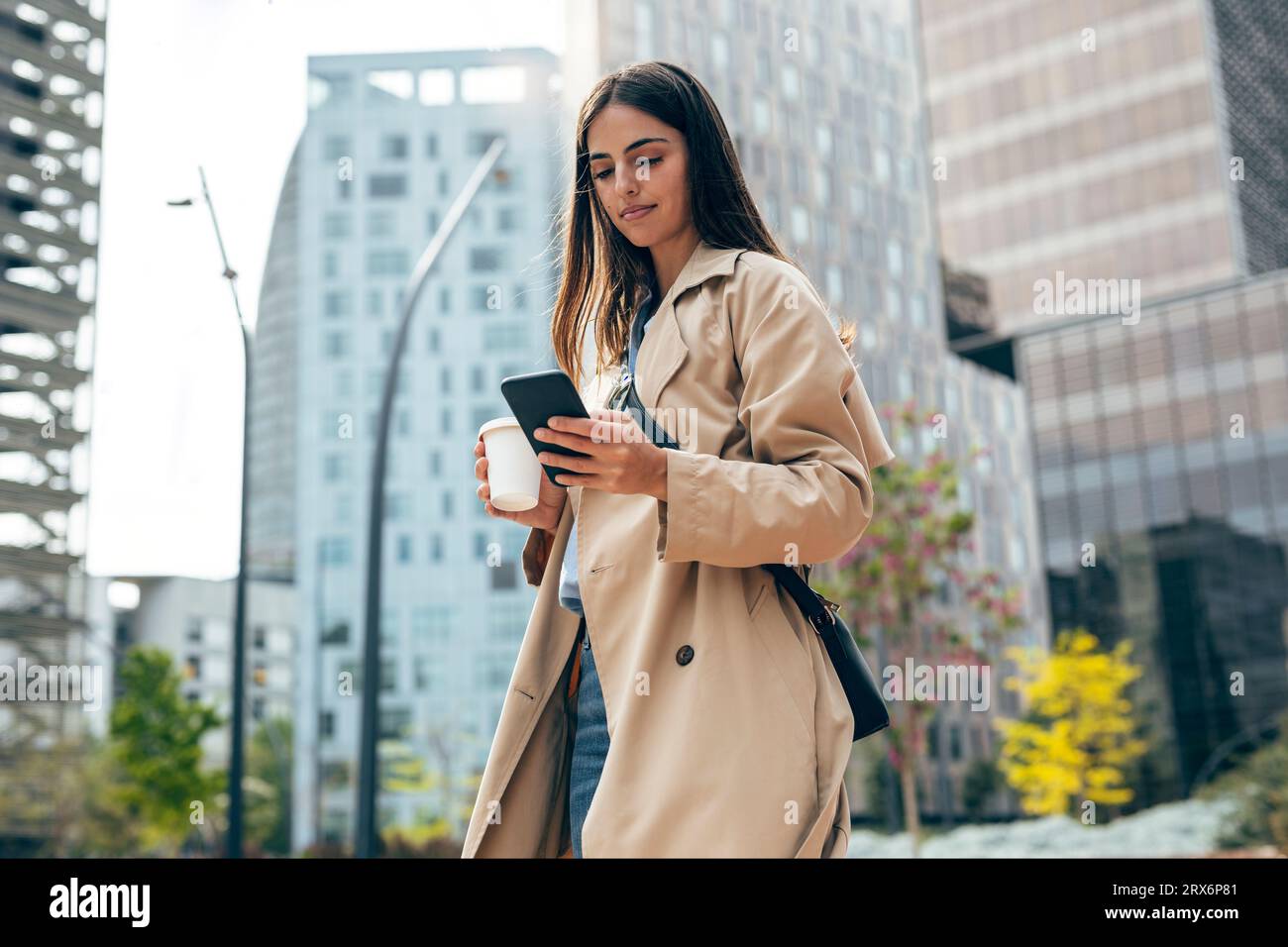 Young woman using mobile phone in city Stock Photo