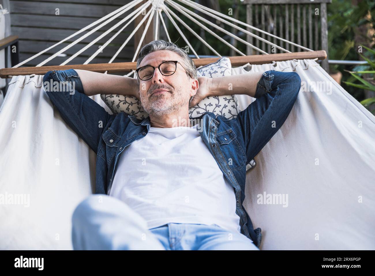 Mature man napping in hammock Stock Photo