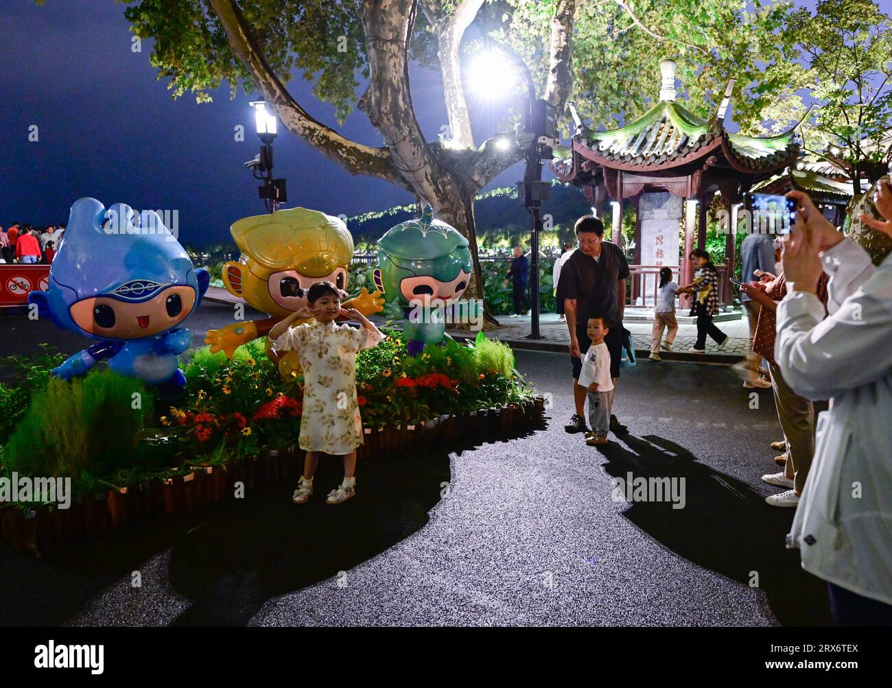 Hangzhou, China's Zhejiang Province. 23rd Sep, 2023. A child poses for photos with mascots of the 19th Asian Games at the West Lake in Hangzhou, east China's Zhejiang Province, Sept. 23, 2023. Credit: Yan Linyun/Xinhua/Alamy Live News Stock Photo