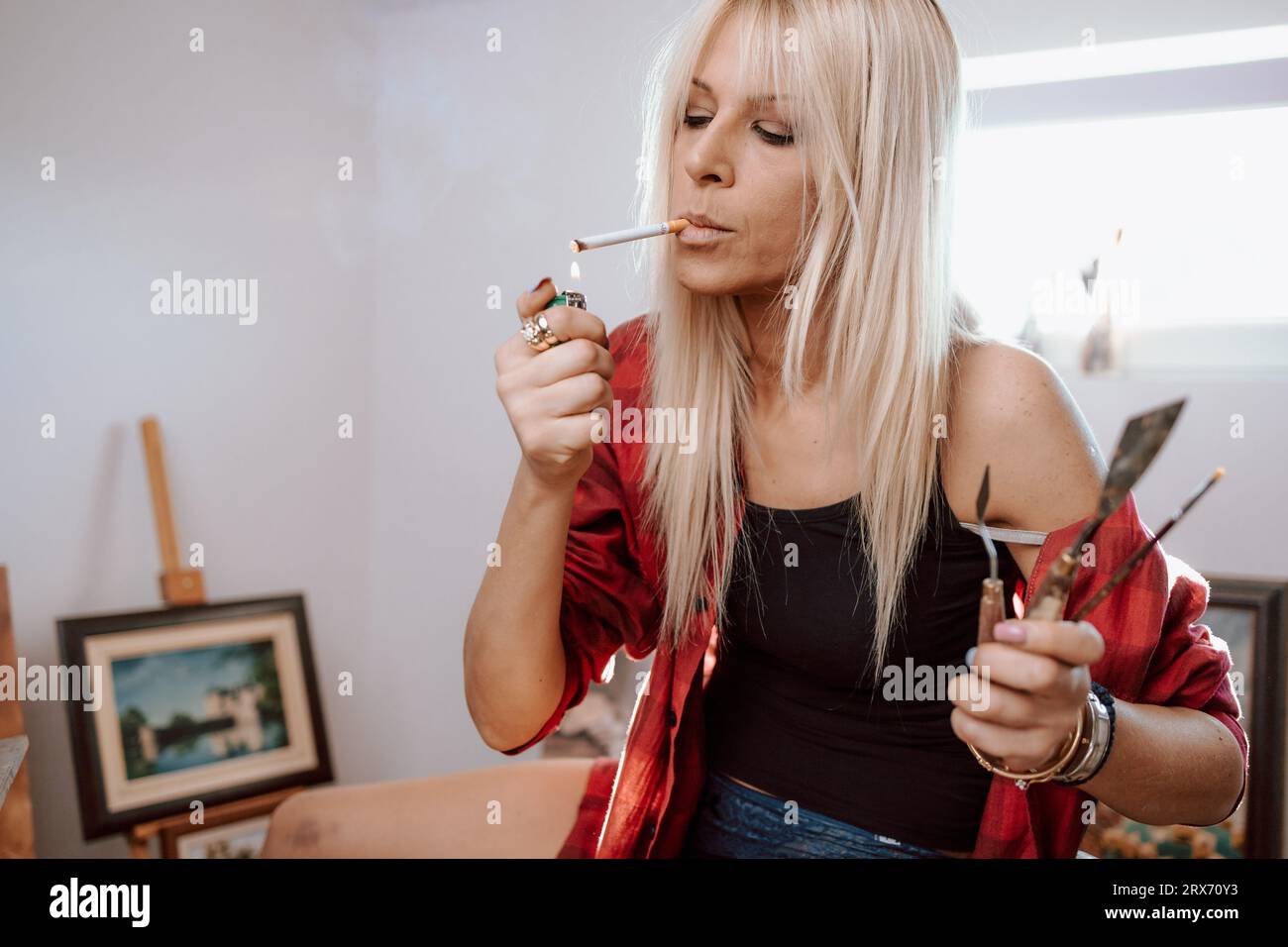 Woman lighting cigarette hi-res stock photography and images