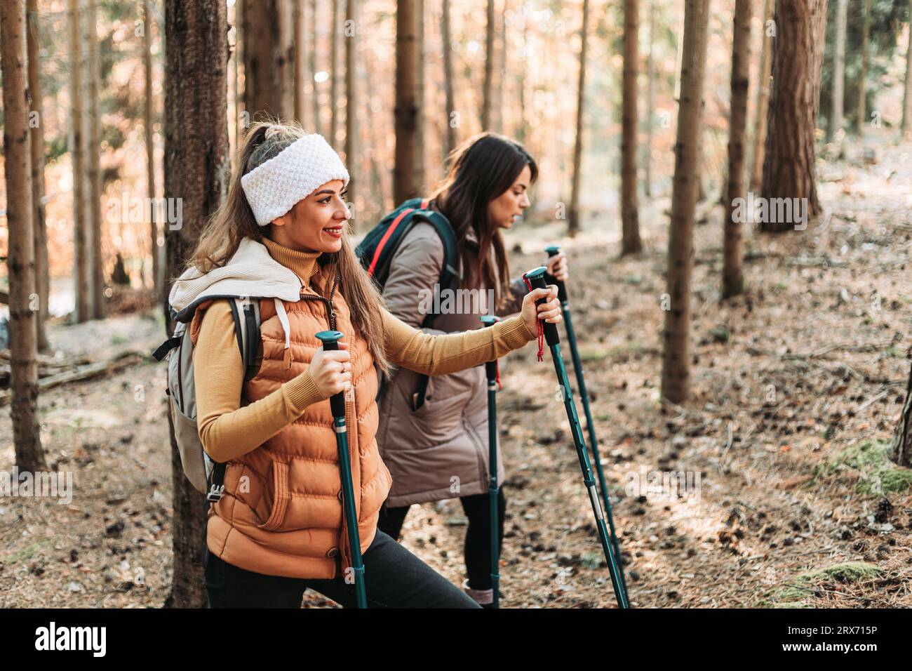 Two girls climbing up the hill together. Autumn colors Stock Photo - Alamy