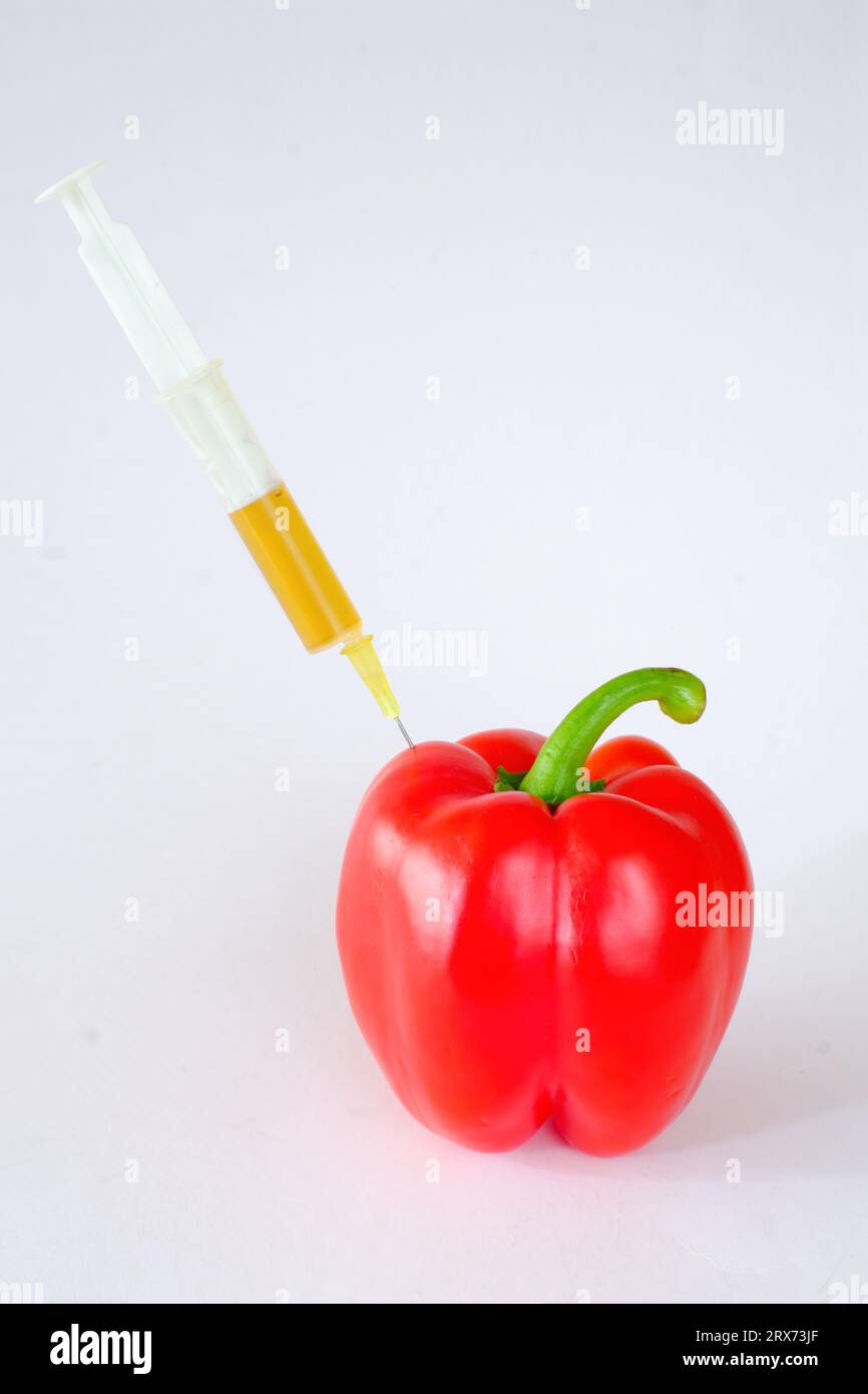 with pesticides contaminated vegetables, bell pepper with syringe,organic farming healthy food concept, symbolic food still life Stock Photo