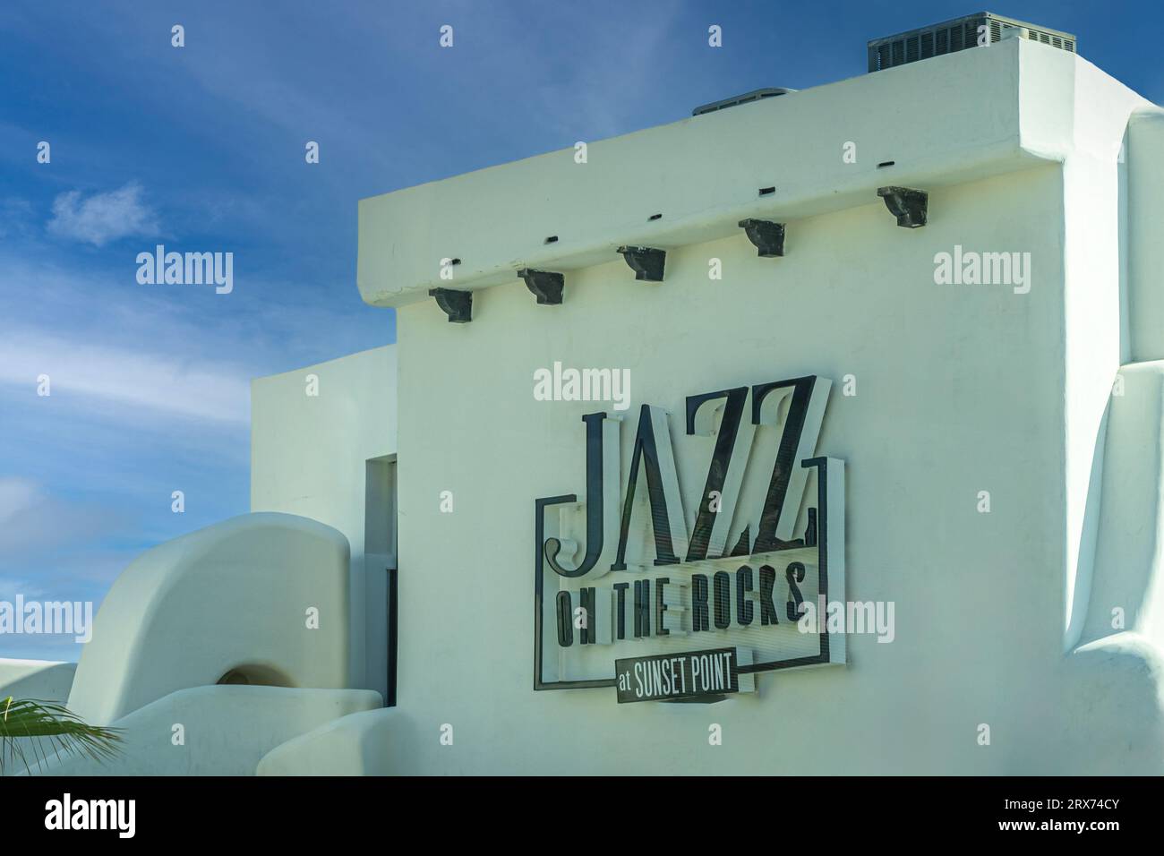 Mexico, Cabo San Lucas - July 16, 2023: Jazz on the Rocks at Sunset Point sign, black on white building wall under blue cloudscape Stock Photo