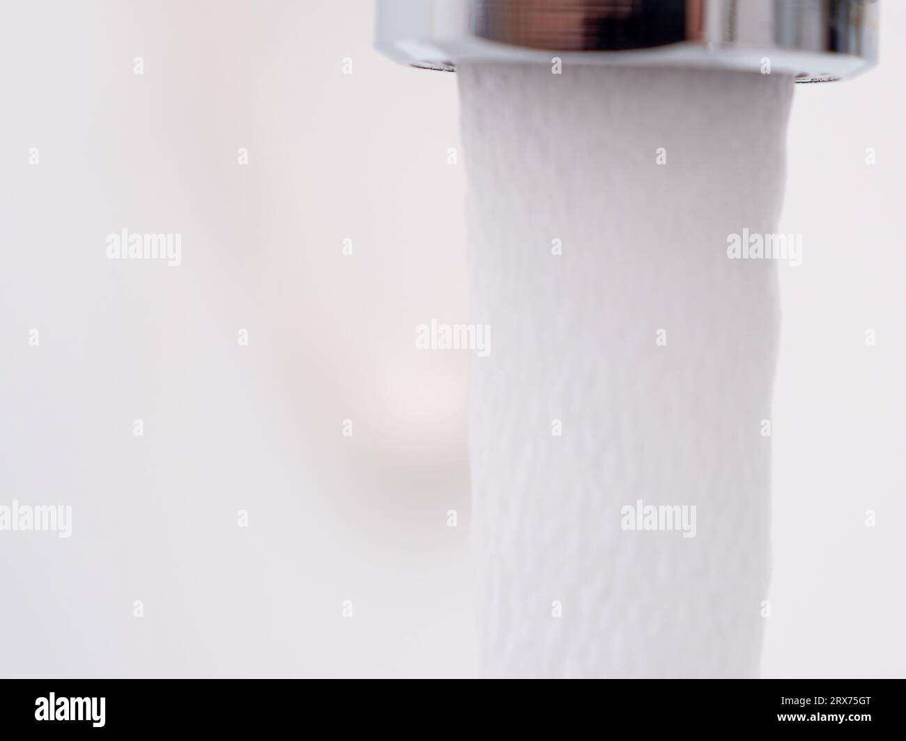 Water flows from a tap, water pressure on a white background. A stream