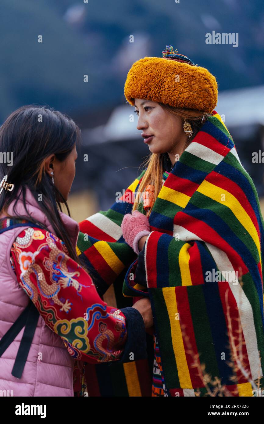 Woman helping dancer to wear colorful attire Stock Photo