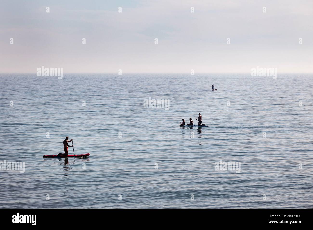 colour image of people paddlenboarding off the coast in Worthing, West Sussex, UK Stock Photo