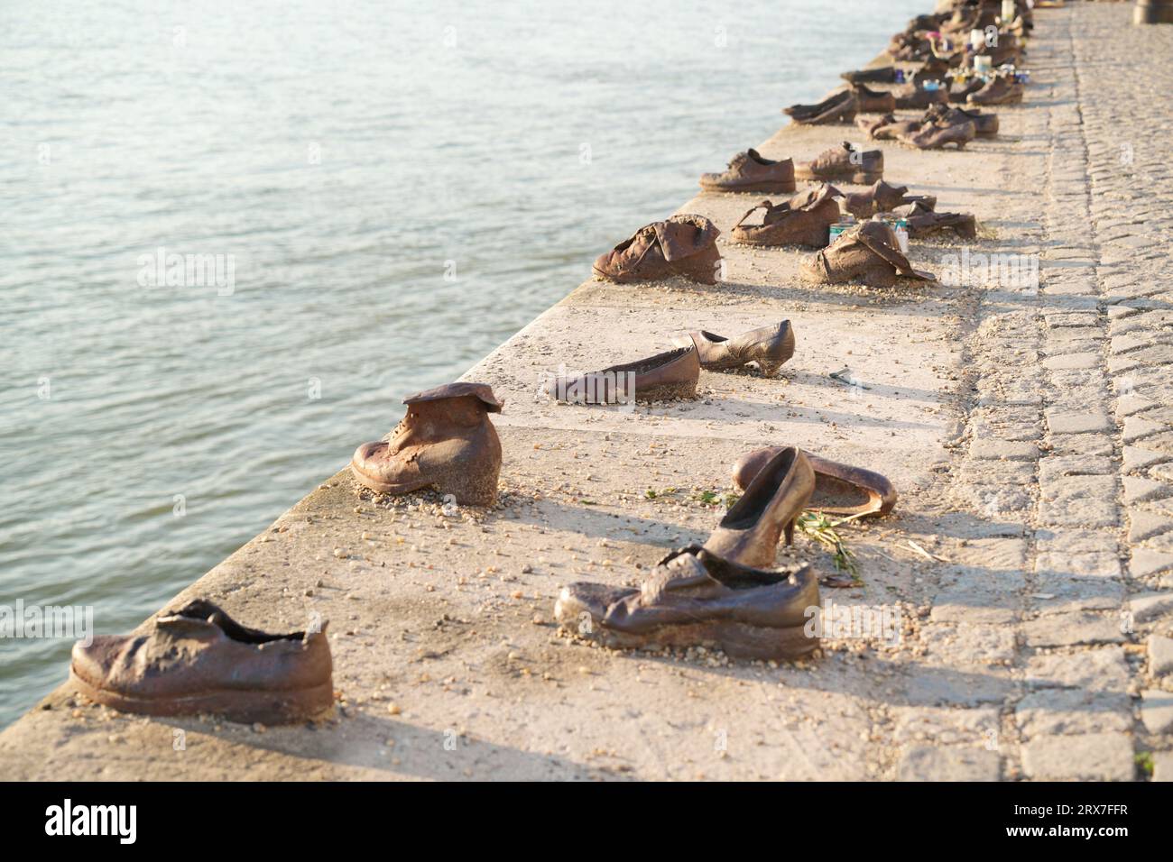 Budapest, Hungary / August 22 2023: Old metal rusty shoes on the parapet of the Danube river embankment in Budapest, Hungary. Monument to the victims Stock Photo