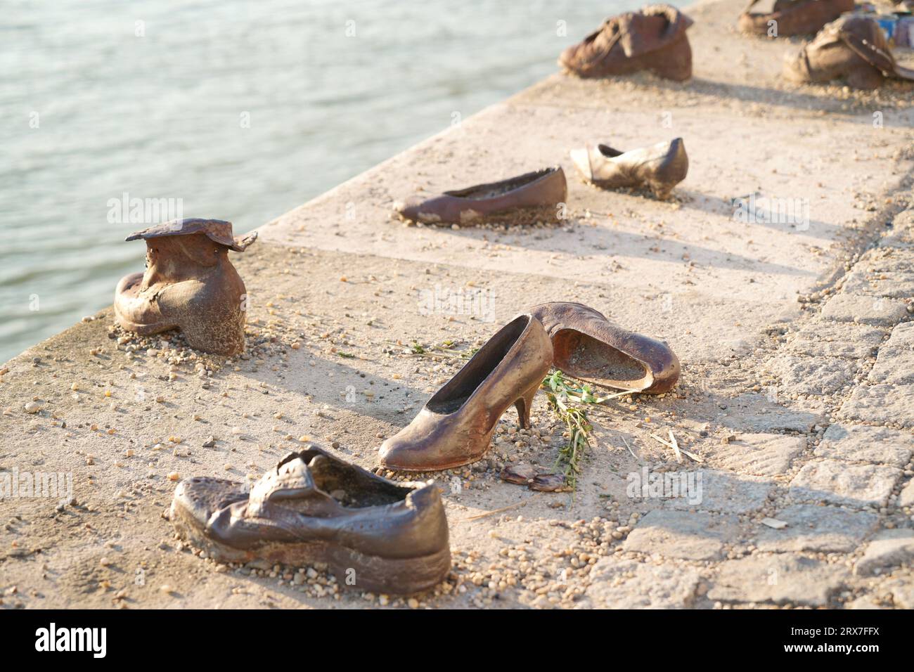 Budapest, Hungary / August 22 2023: Old metal rusty shoes on the parapet of the Danube river embankment in Budapest, Hungary. Monument to the victims Stock Photo