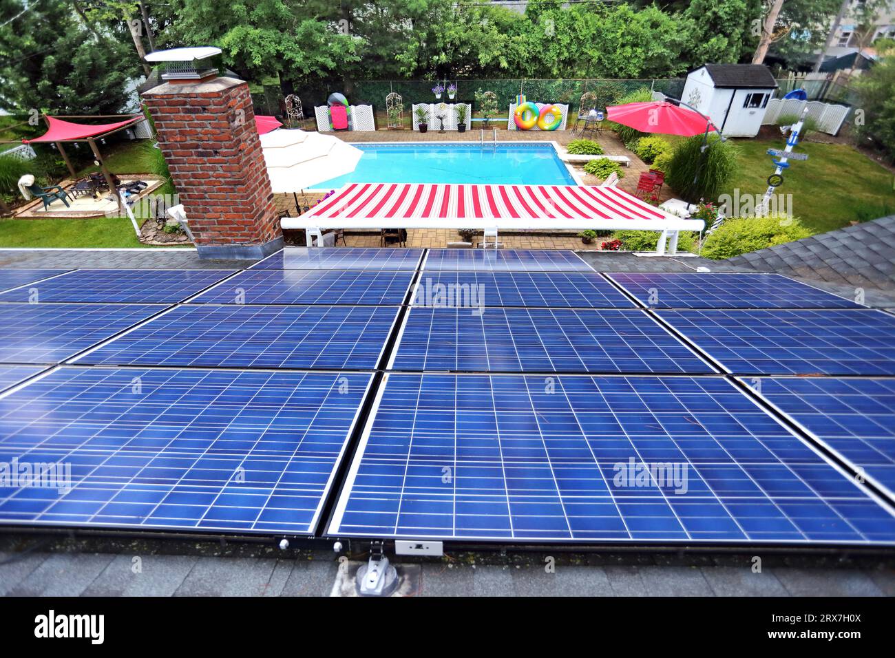 Backyard inground pool and patio and rooftop solar panels, Long Island, NY Stock Photo