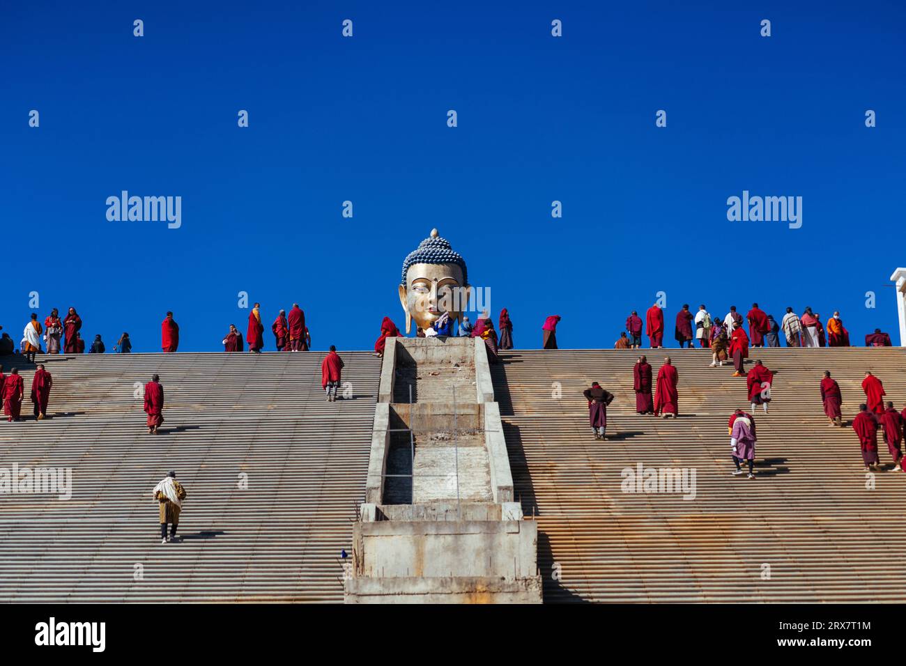 Buddha statue view from low angle with monks Stock Photo