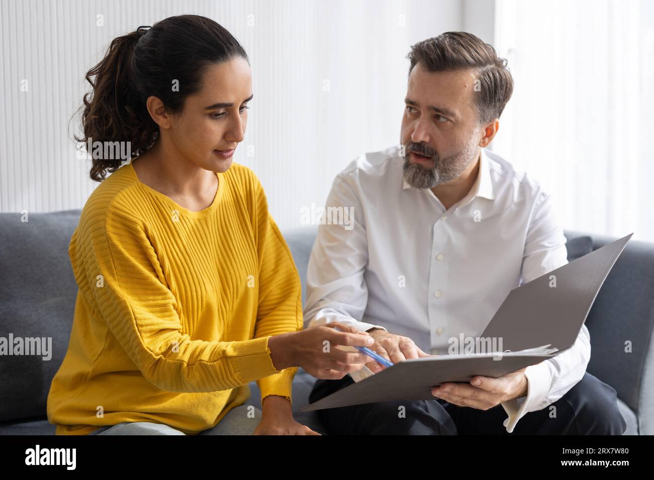 Senior professional business agent or financial lawyer tax advisor talking with indian woman about insurance contract document Stock Photo
