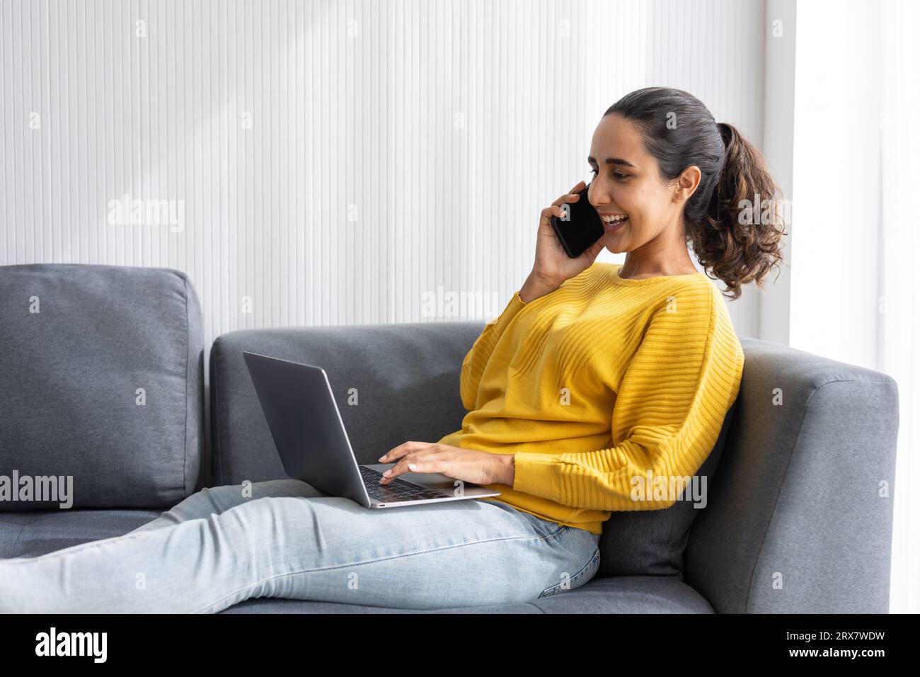 University teen girl or hispanic indian business woman sitting relax on sofa happy enjoy with modern technology device working at home Stock Photo