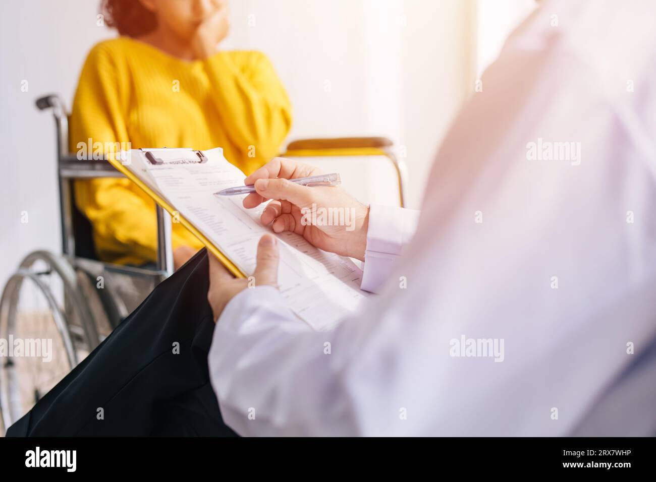 Psychiatrist doctor collect data talk with patient on wheelchair for mental care health problems check followup in hospital clinic Stock Photo