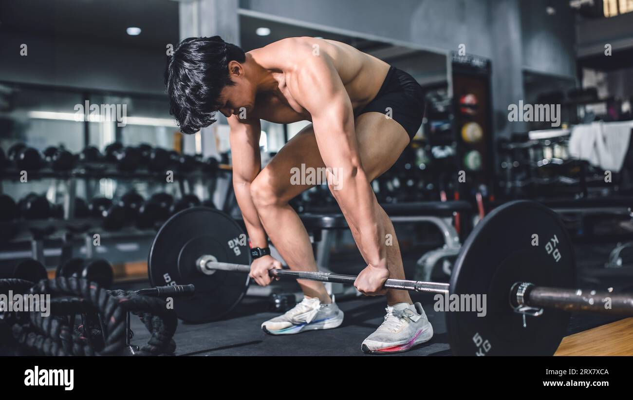 Gym fitness weightlifting deadlift Asian man bodybuilding powerlifting indoor sport club. Bodybuilder doing barbell weight lifting training workout wi Stock Photo