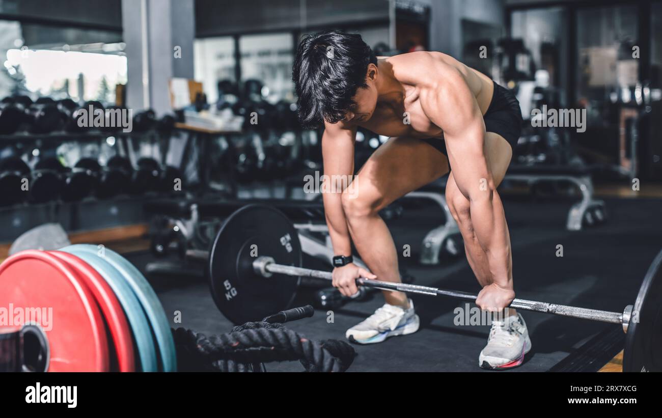 Gym fitness weightlifting deadlift Asian man bodybuilding powerlifting indoor sport club. Bodybuilder doing barbell weight lifting training workout wi Stock Photo