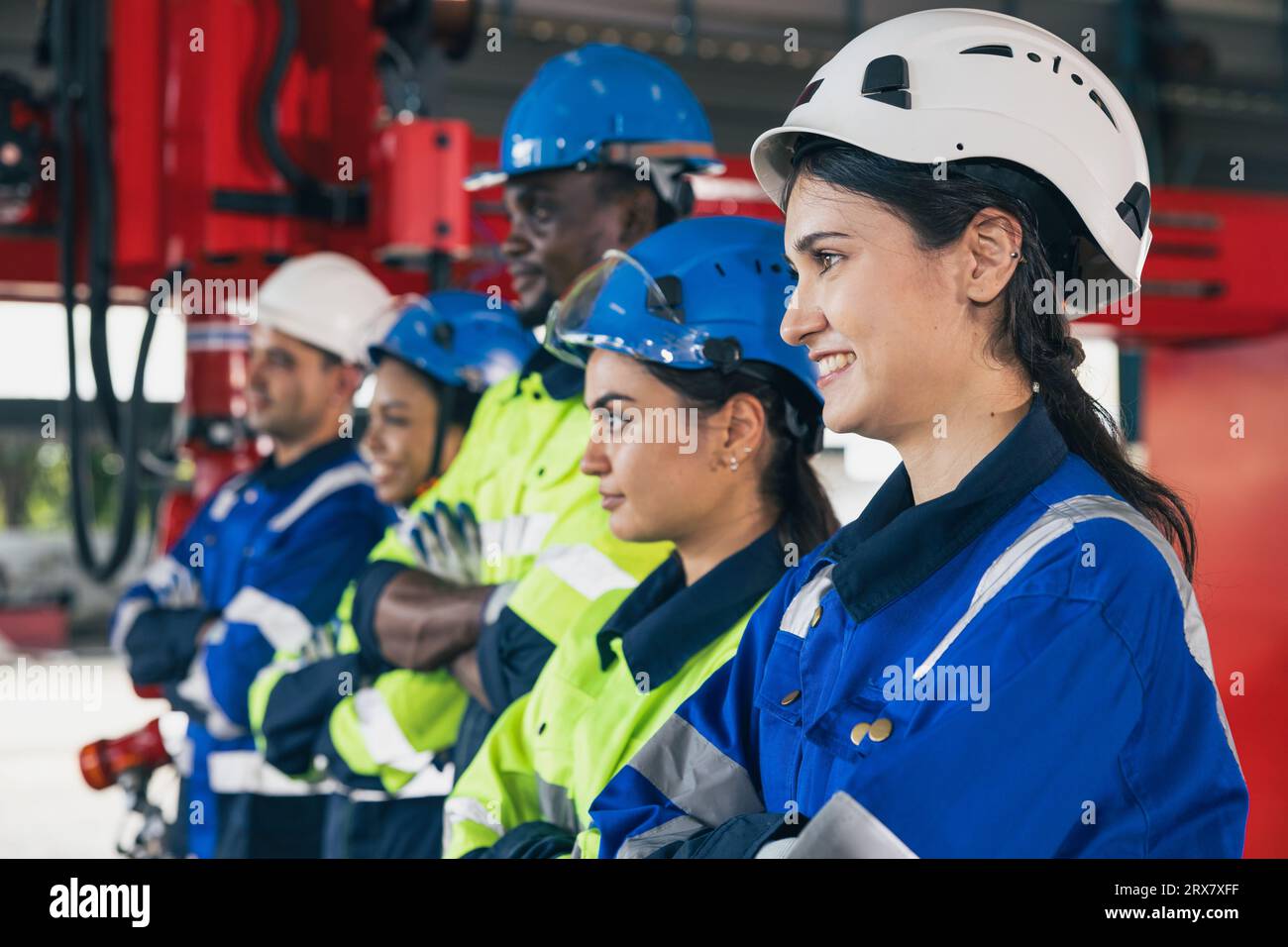 Group of engineering team happy worker diversity technician. woman engineers standing arm crossing in assembly plant. Industry staff working people te Stock Photo