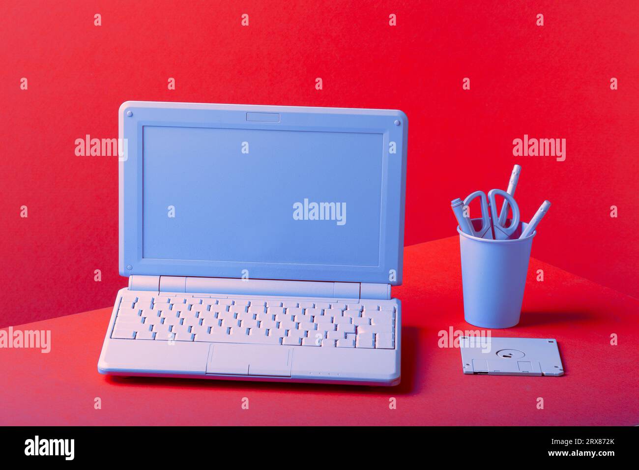 Blue laptop on a red background, with office supplies. High quality ...