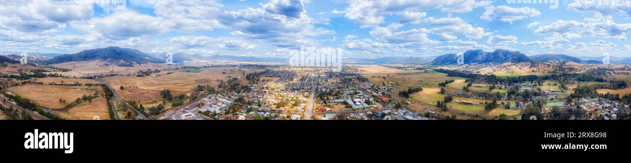 Scenic argiculture valley with Gloucester rural town in Australia at Barrington tops mountains - wide aerial panorama. Stock Photo