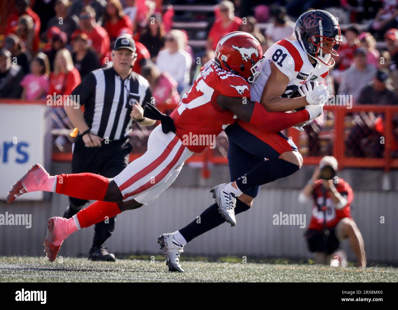 Montreal Alouettes receiver Austin Mack, right, is tackled by Calgary  Stampeders linebacker Micah Awe during the second half of a CFL football  game in Calgary, Alberta, Saturday, Sept. 23, 2023. (/Jeff McIntosh/The