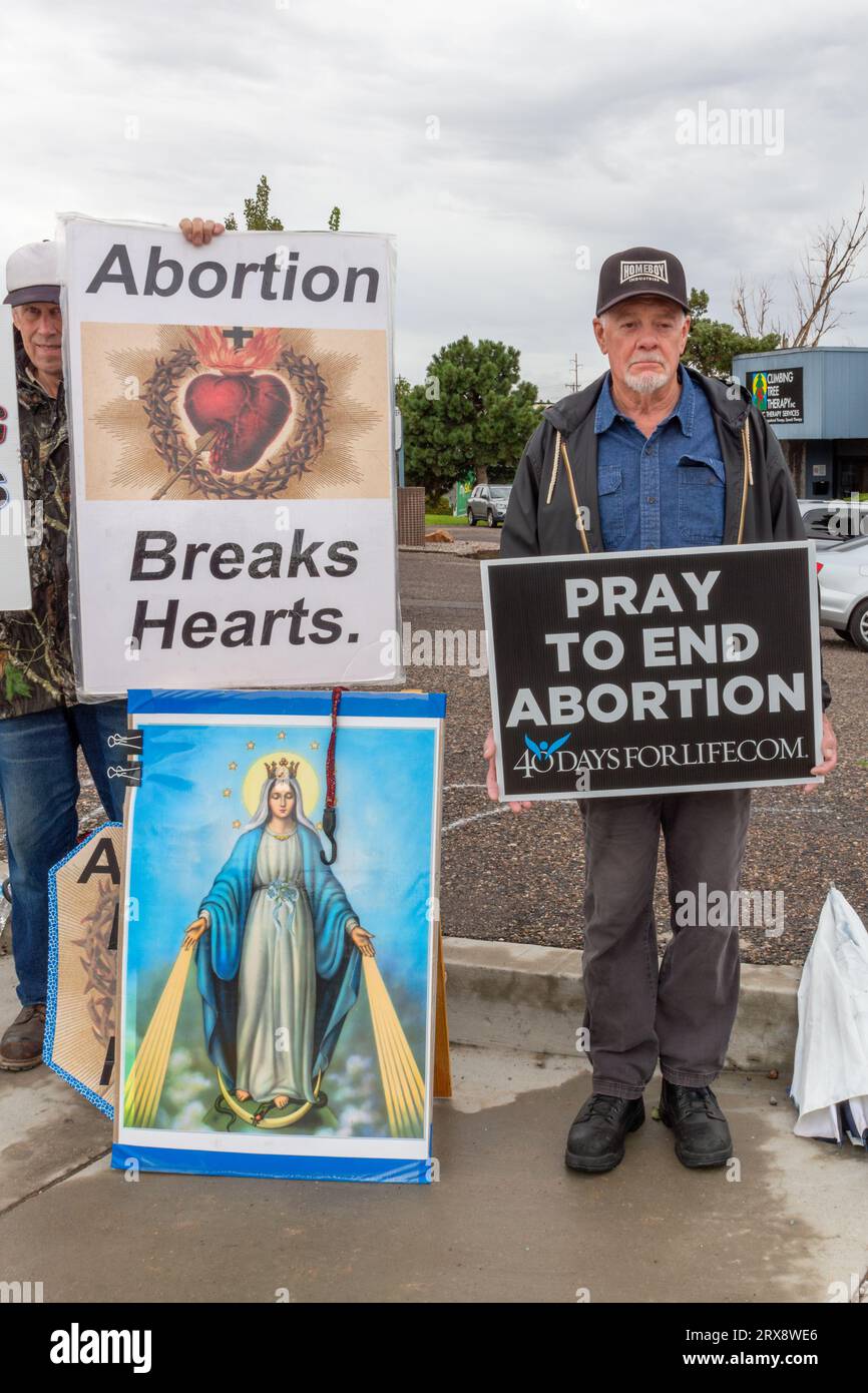 Senior protestors stand on street corner in Albuquerque, New Mexico, holding anti-abortion pro-life signs and large image of Virgin Mary, USA. Stock Photo