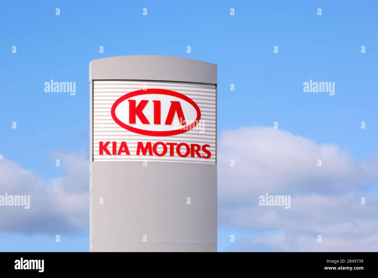 Kia Motors sign outside a local dealership photographed against a blue sky.. Stock Photo