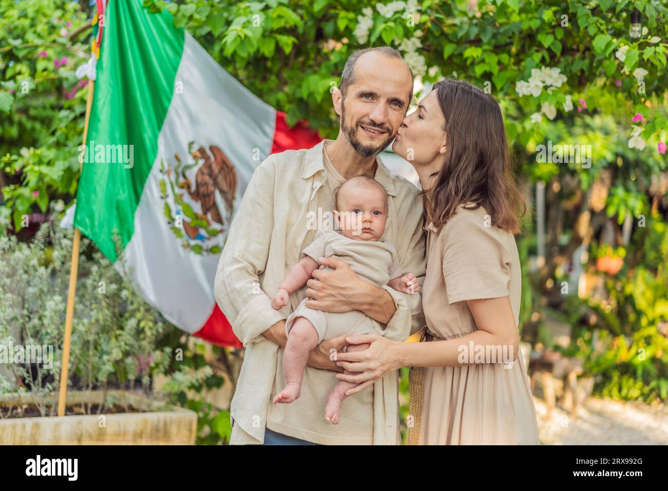 Immigrant family in front of the Mexican flag. New Mexicans. Childbirth in Mexico Stock Photo