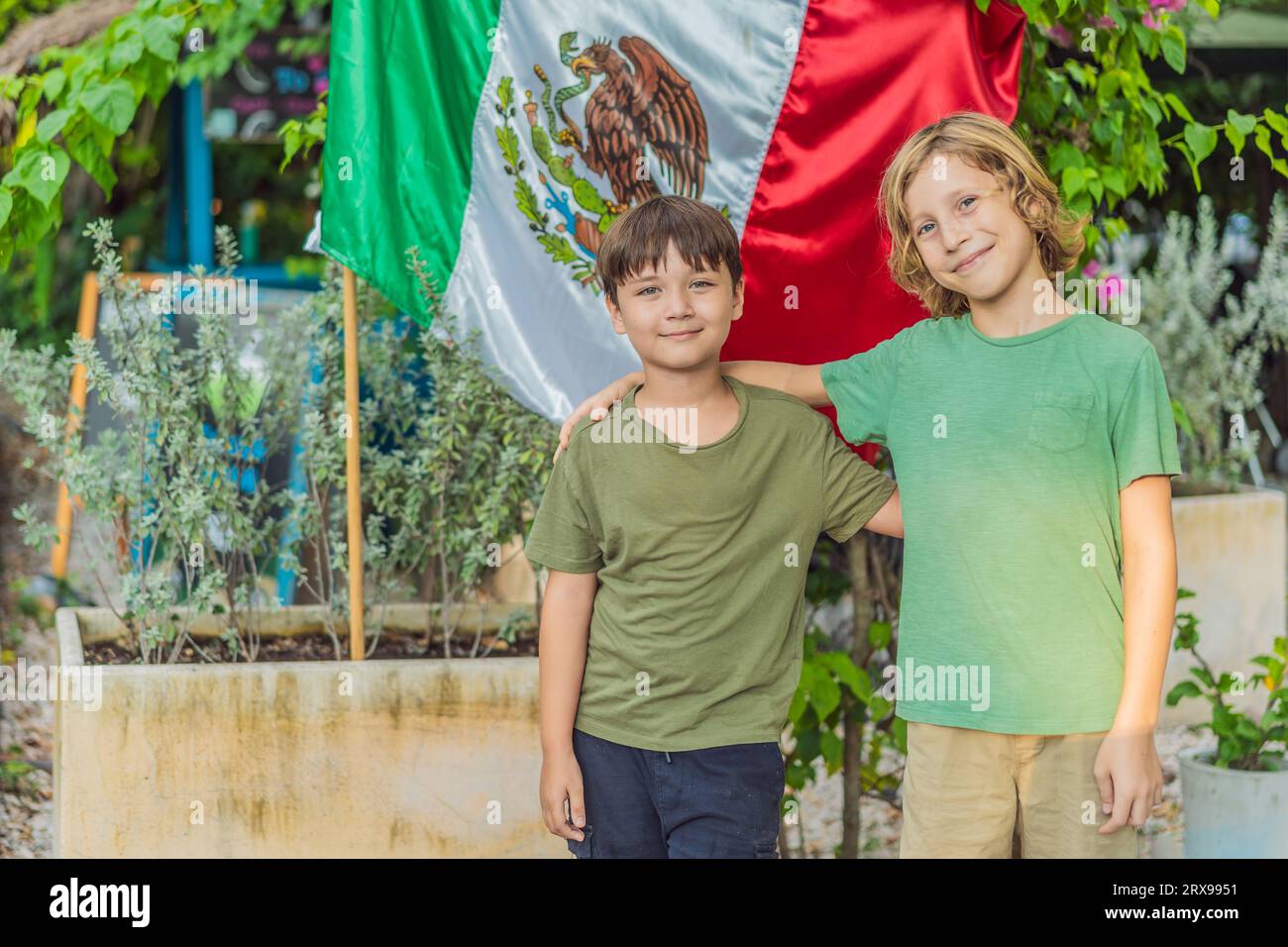 Immigrant boys in Mexico in front of the Mexican flag. New Mexicans Stock Photo