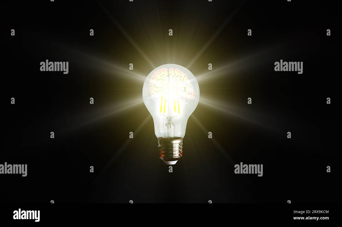 An illuminated or glowing lightbulb on a dark background represents new ideas, innovation, creativity, understanding, knowledge, and inspiration. Stock Photo