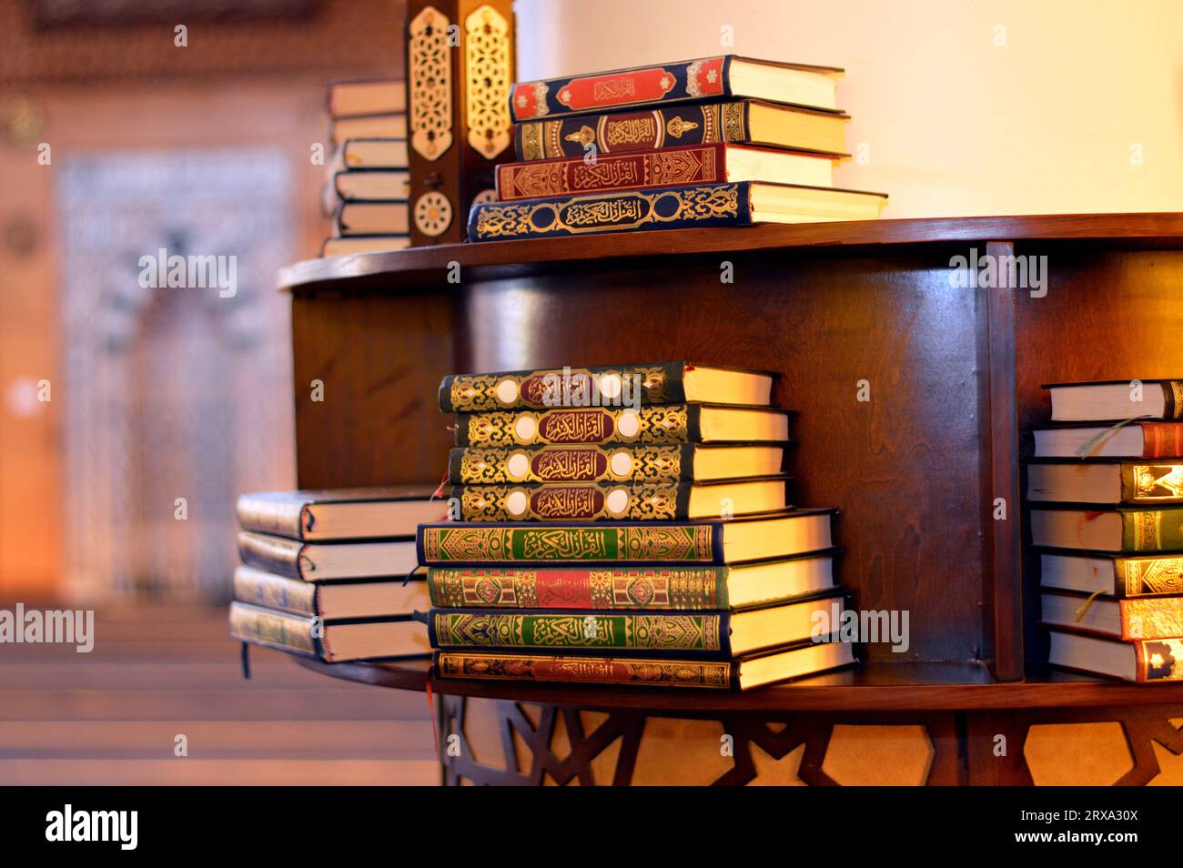 Holy Quran books in a row standing on a wooden shelf inside a mosque, English translation of the