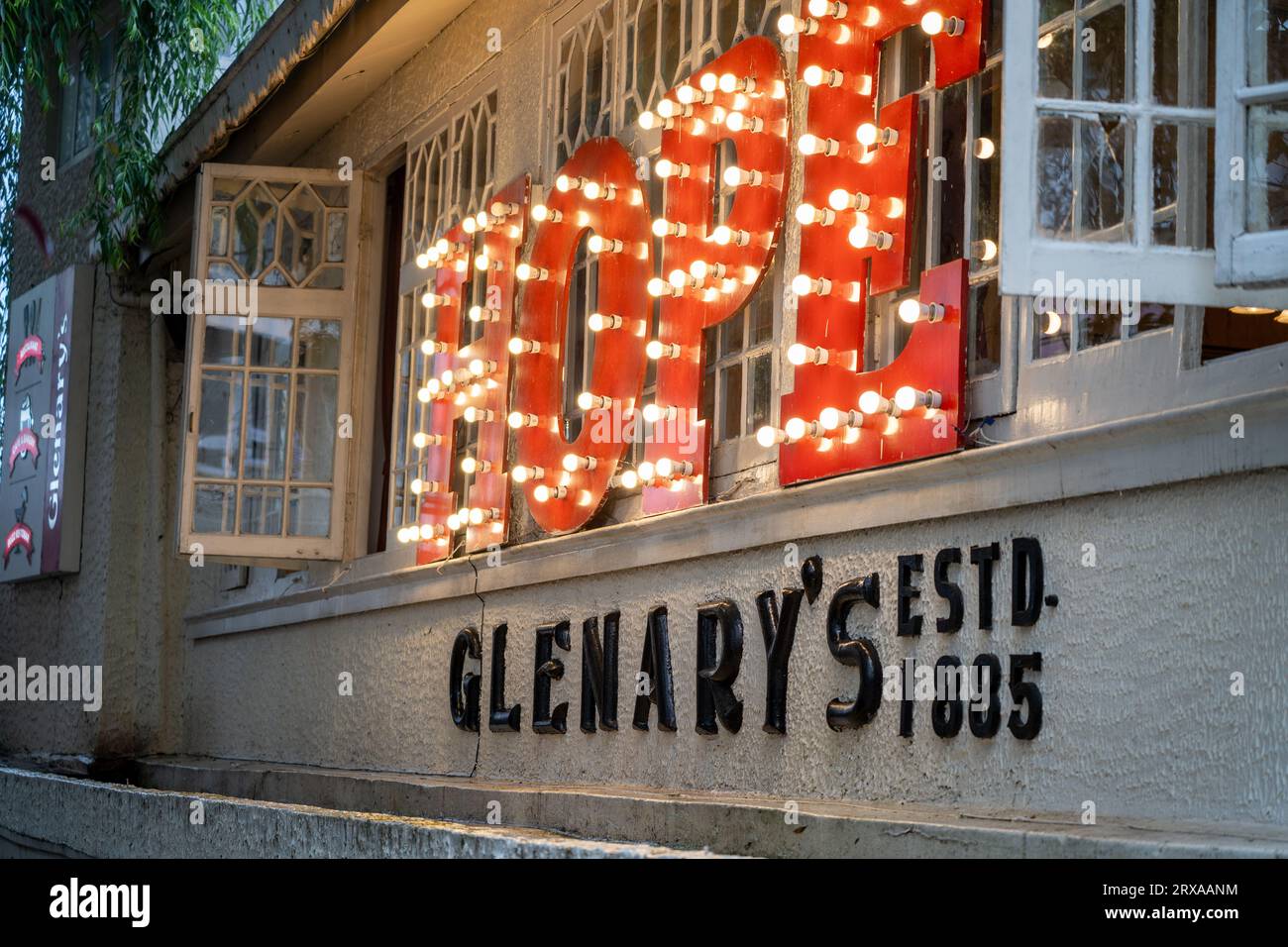 Panning shot showing the signboard of Glenary's Hope showing the famous landmark cafe bakery that is a must visit for tourists on mall road in Stock Photo