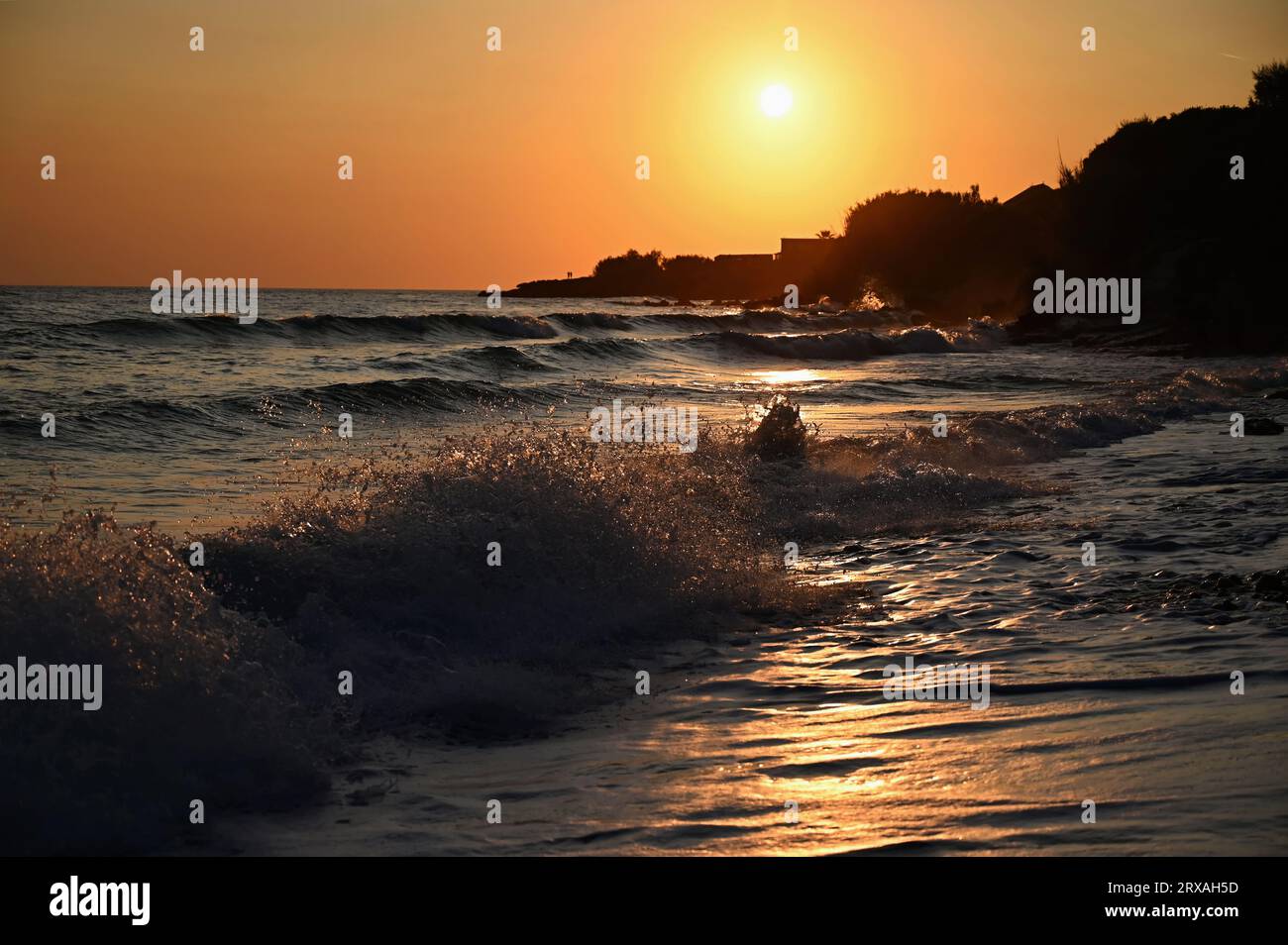 Beautiful colourful sunset on the beach with the sea and waves. A concept for travel, holidays and summer holidays by the sea. Greece - Corfu island - Stock Photo