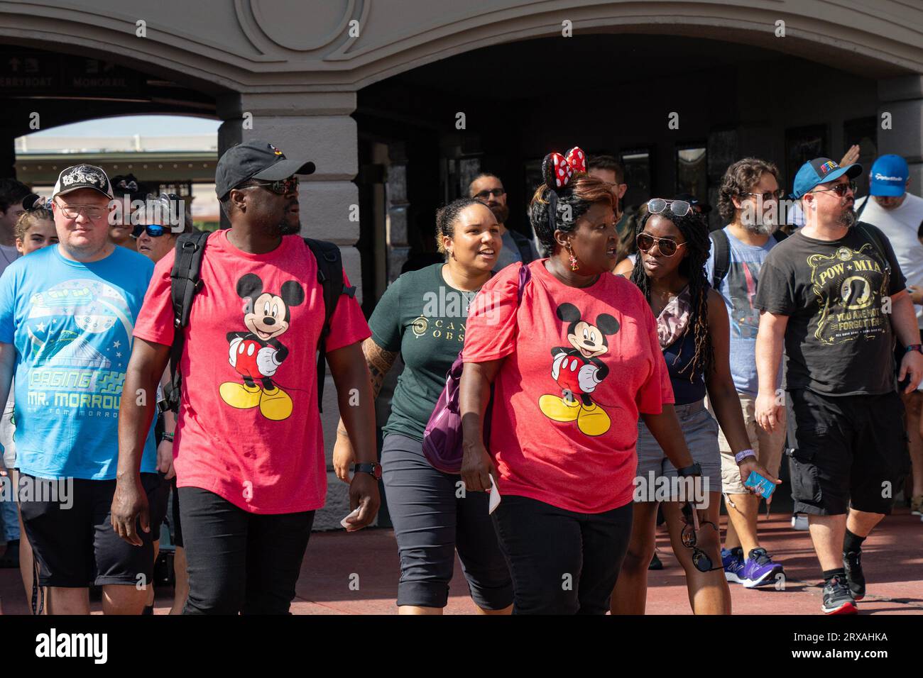 Orlando, USA - July 25th, 2023: A couple of tourists with matching Mickey Mouse t-shirts entering Disney's Magic Kingdom. Stock Photo
