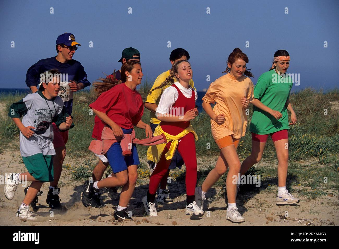 Young people jogging on the beach, group Stock Photo