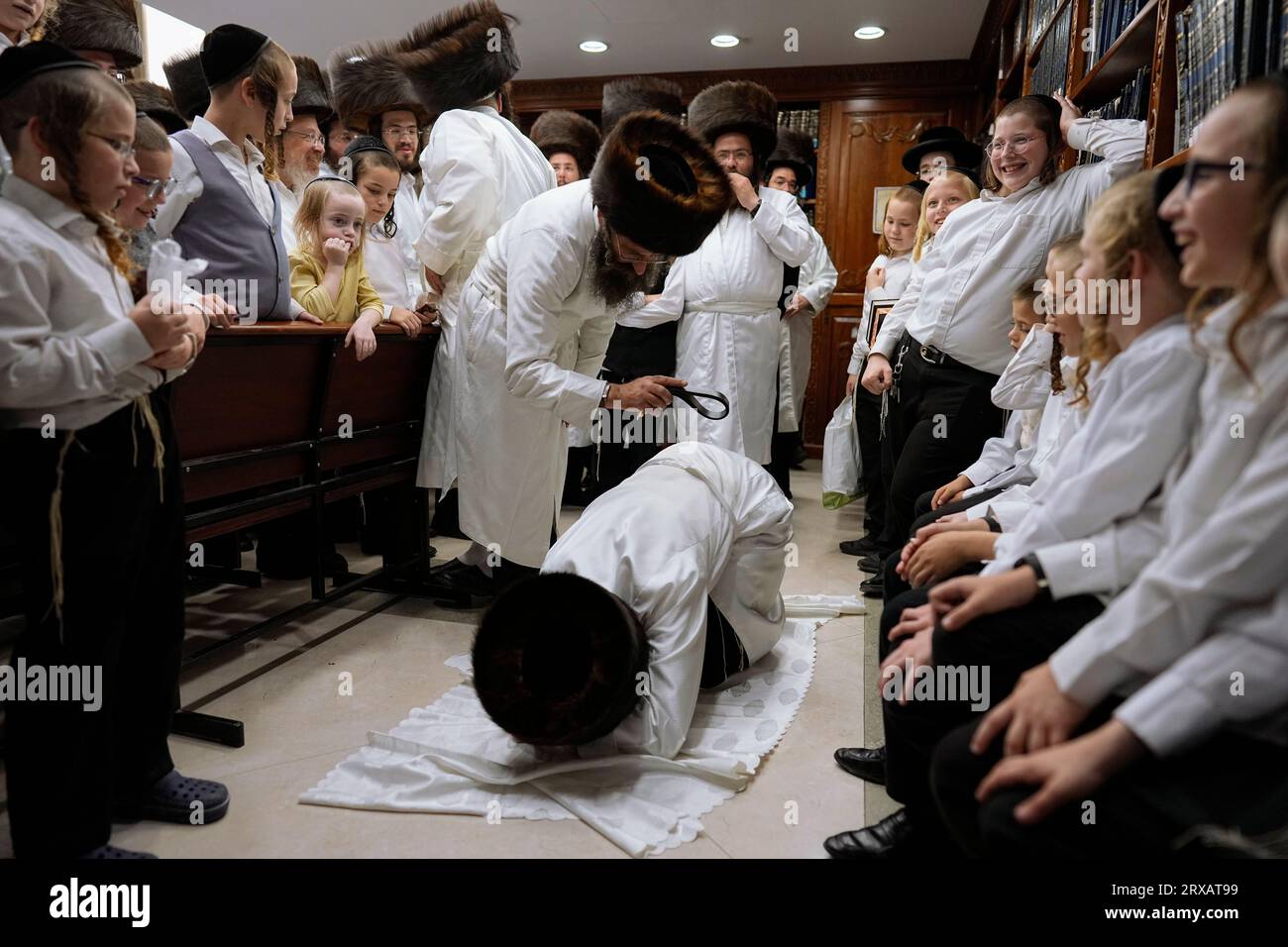 An ultraOrthodox Jewish man whips a member of his Hasidic dynasty with