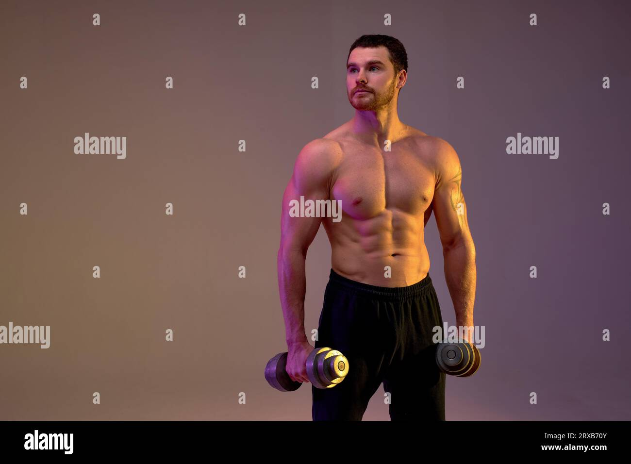 serious ambitious sportsman with dumbbells in hands looking up, close up portrait, strength training. hobby, interest,healthy lifestyle Stock Photo