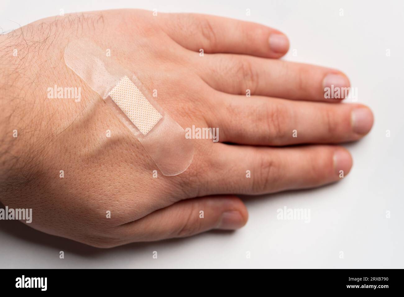 Aid tape on human skin hand isolated on studio background Stock Photo