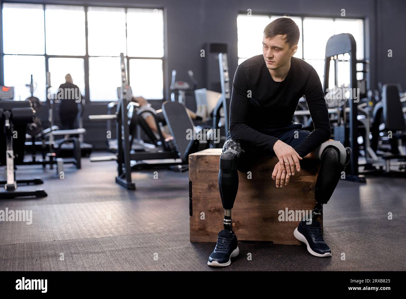 young thoughtful exhausted upset athlete looking sideways, full length photo. copy space. depression, tiredness Stock Photo