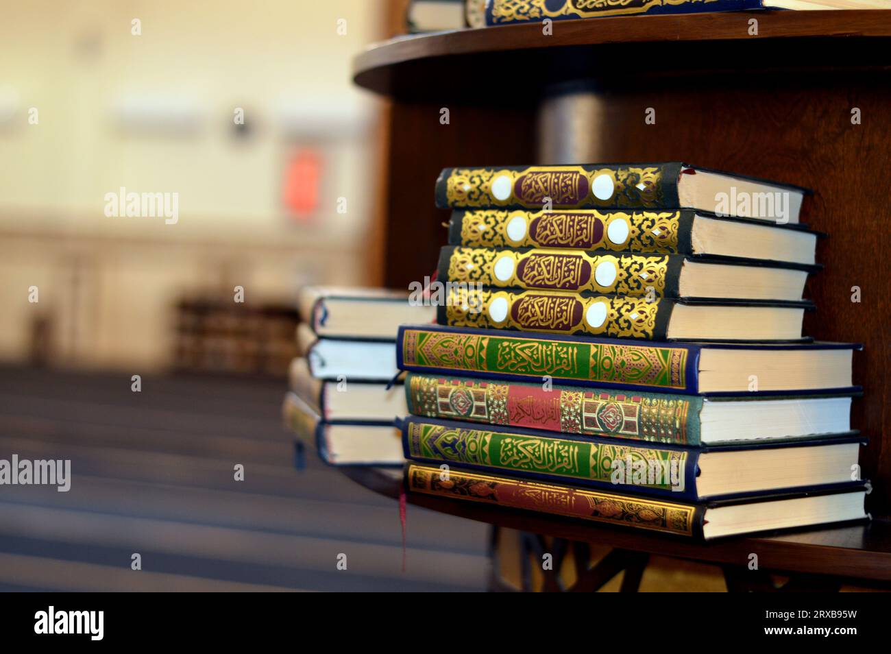 Holy Quran books in a row standing on a wooden shelf inside a mosque
