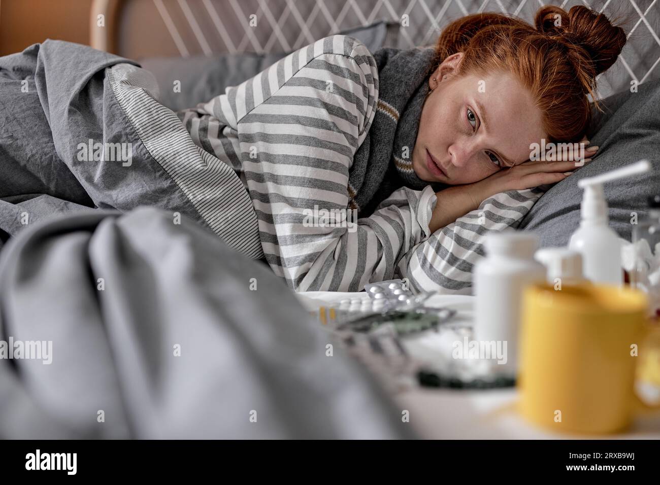 sick pale redhead girl cannot sleep, fall asleep as she has terrible headache, close up portrait Stock Photo