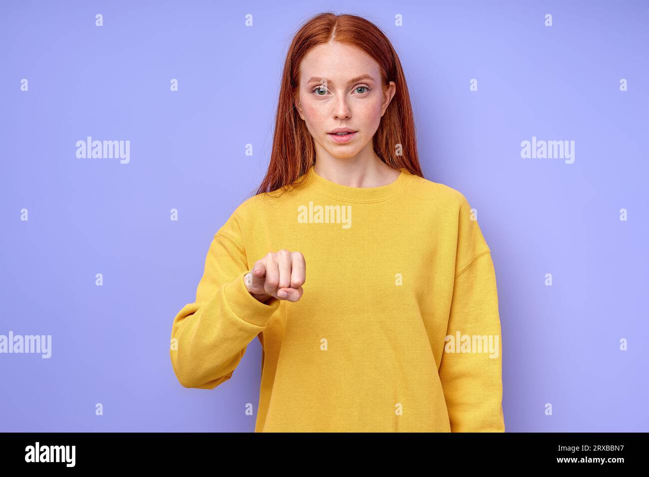 serious confident girl or female teacher with long red hair shows the