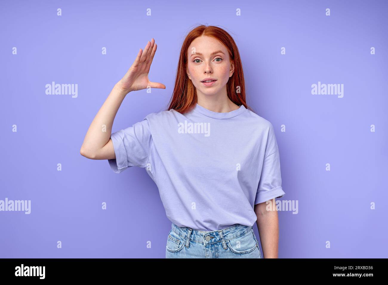 attractive readhead woman in casual clothes with raised palm demonstrating no gest, close up portrait studio shot, teacher entertaining children, kids Stock Photo