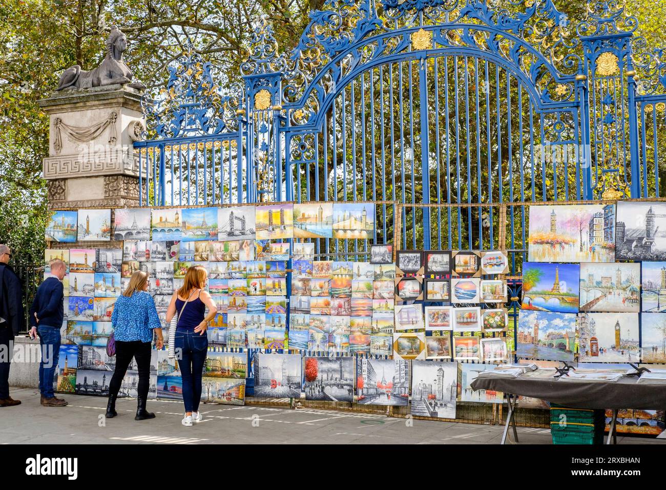 Paintings for sale hung on the railings of The Green Park at Piccadilly Art Market, London, UK Stock Photo