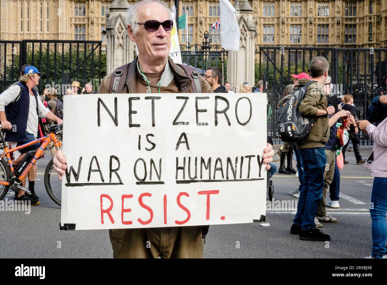 A man holds a placard claiming that a net zero carbon emissions future is a war on humanity and should be resisted. London UK. Stock Photo