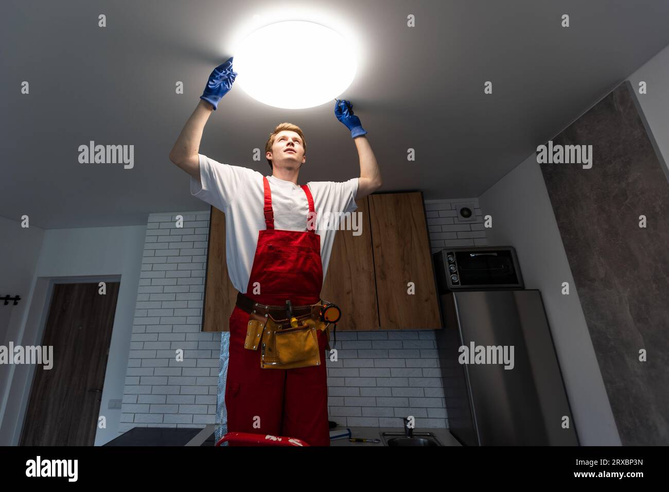An electrician is installing LED spotlights on the ceiling Stock Photo ...