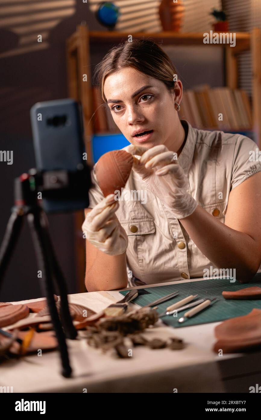 Female archaeologist doing research, uses smartphone to share discovery